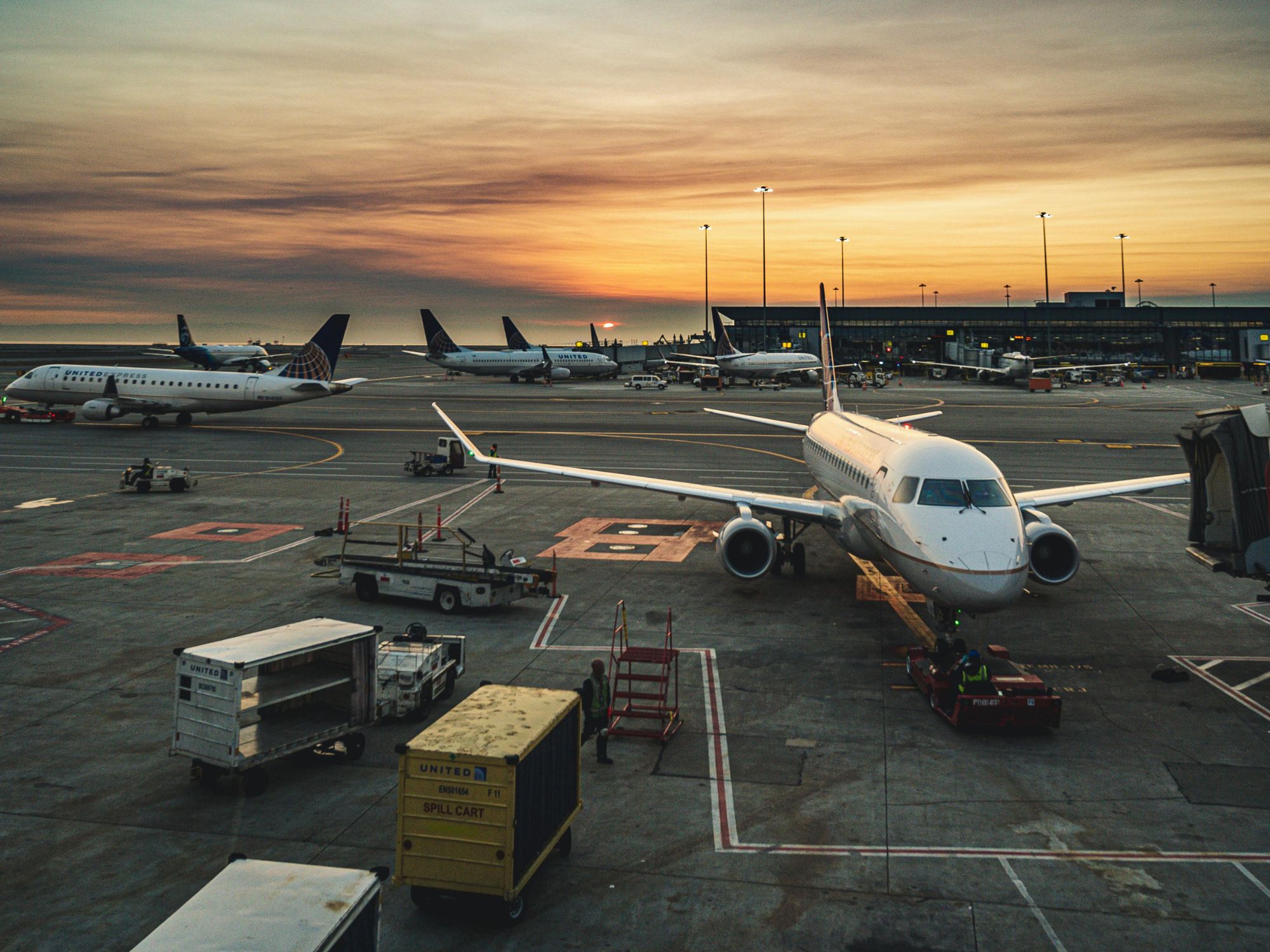 Piazzale aeroportuale con aeromobile e mezzi di rampa in operazione